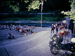 四万十川の川原で太鼓に興じる酒宴の傍らに停まっているバイクの写真