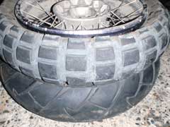 舗装路用タイヤの上に重ねた悪路用タイヤが付いたホイルの写真
