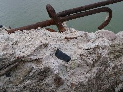 アーチ橋の風化して崩れている断面に黒曜石が露出している写真
