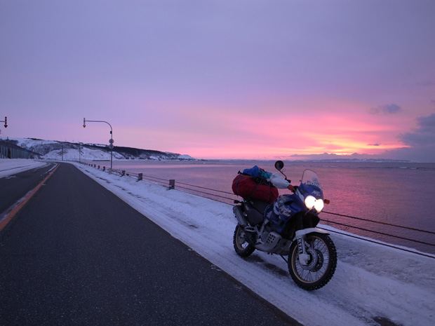 宗谷海峡を美しく染める大晦日の夕日に浮かぶバイクの写真