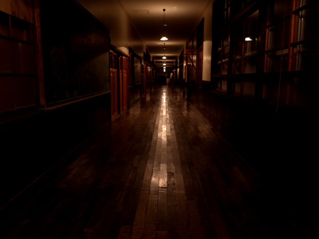 古い校舎の磨かれた廊下に映る光の帯の写真