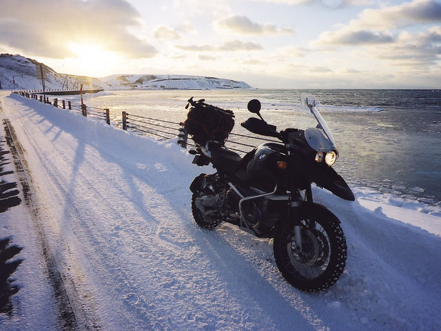 元旦宗谷岬ツーリング2022(エァー)思いを巡る旅_2003年元日の宗谷海峡にて流氷の海岸で夕日を背に佇むバイクの写真