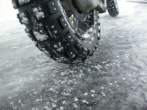 大型バイクのリアタイヤのスパイクピンがアイスバーンに刺さっている写真