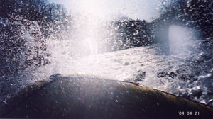 ボートにぶつかり飛び散る水しぶきの写真