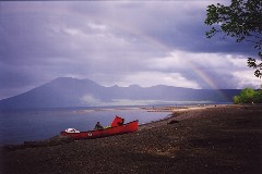 誰もいないキャンプ場に上陸して灯台代わりに見上げてきたフップシ岳にかかる虹を見上げているカヌーの写真