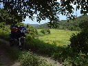 片田舎の木陰で休む伴走バイクの写真