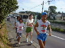 伴走の方を三人従えて走るランナー澤本さんの写真