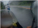 猛烈な嵐の中、風に向かって前進していくランナーの後ろ姿をバイクより見た写真