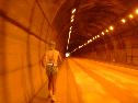 高圧ナトリウムランプの発するオレンジ色の光に包まれて進む長い長居トンネルの中の写真