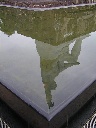 周囲の水面に逆さに写っている長崎平和祈念像の写真