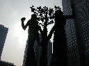 木をはさんで二人並んでいるオブジェの写真