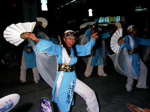 青い衣装を纏いセンスを広げて踊る踊り子の写真