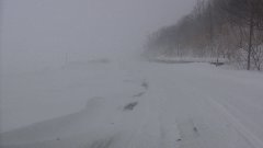 サロマ湖から吹き付ける吹雪によって吹き溜まりで埋まりつつある国道の写真