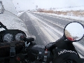 雪解けが進んだシャーベット路面を走っているバイクの写真