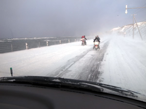 元旦宗谷岬ツーリング2013_雪道で両足を着いたまま移動している原動機付き自転車