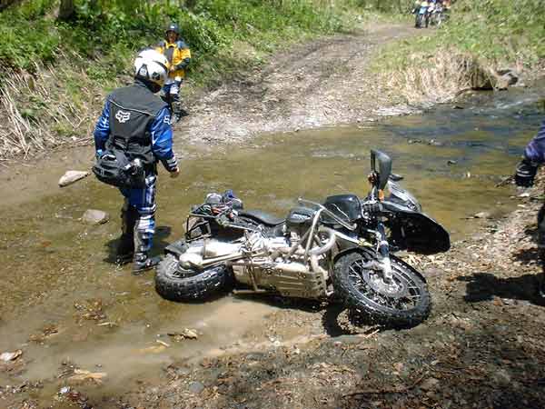 川の中で転倒しているバイクの写真