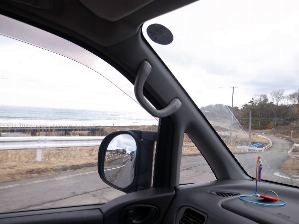 国道45号線を走る車の窓から見える海の写真