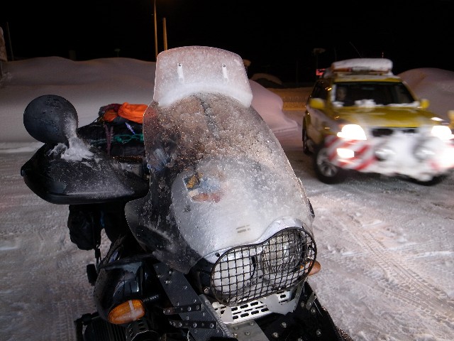 酷い吹雪を突破してきた直後のバイクのシールドを覆っている吹雪の残骸の写真