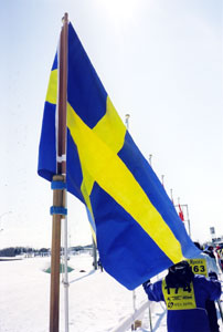 スタートラインにはためく一本杖に付けたれたスェーデン国旗の写真