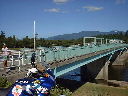 猛暑の中、涼しげな水色に塗られた橋を渡るランナーの写真