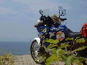 海の見える高台で一休みしているバイクの写真