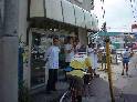 自転車の伴走を従えて、店の前で声援をしてくれている薬屋さんの前を通過している写真