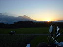 遠く美しい単独峰の峰に沈みゆく夕日の写真