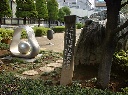 四十万都市誕生記念植樹の碑とダルマをくりぬいたような銀色のオブジェの写真